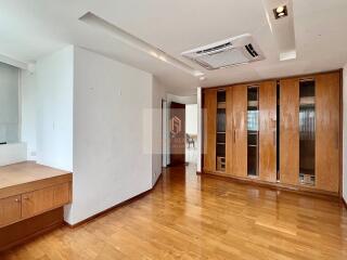 Spacious living room with wooden flooring and built-in wooden cabinets