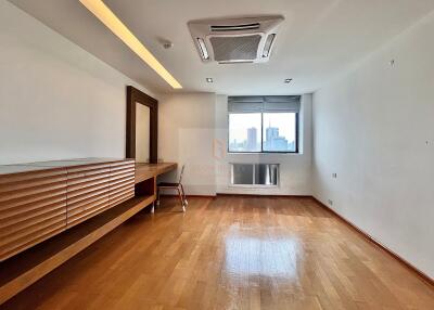 Spacious bedroom with wooden floor and large window