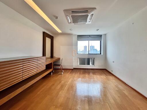 Spacious bedroom with wooden floor and large window