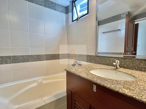 Modern bathroom with a bathtub and a granite countertop sink