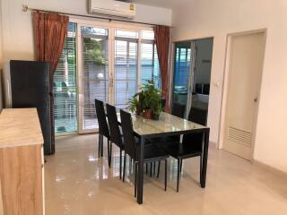 Dining area with glass table and black chairs, air conditioning, and access to outdoor space