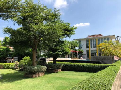 Modern clubhouse surrounded by lush greenery on a sunny day