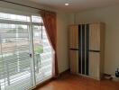 Bedroom with a large window and wardrobe