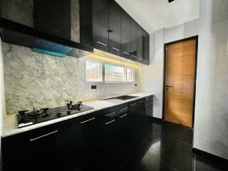 Modern kitchen with marble backsplash and black cabinets