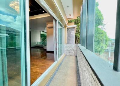 Modern glass-enclosed balcony with view into living area