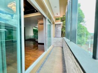 Modern glass-enclosed balcony with view into living area