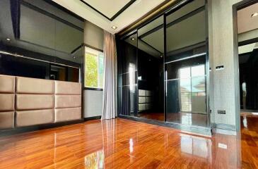 Spacious bedroom with wooden flooring and mirrored closet