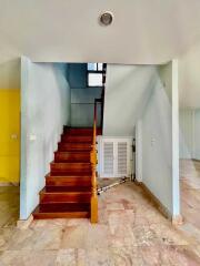 Staircase leading to the upper floor with a storage cabinet underneath