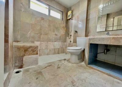 spacious bathroom with tiled walls and floor
