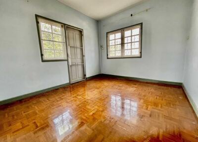 Spacious bedroom with wooden floor and large windows