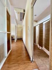 A corridor with wooden flooring and multiple doors