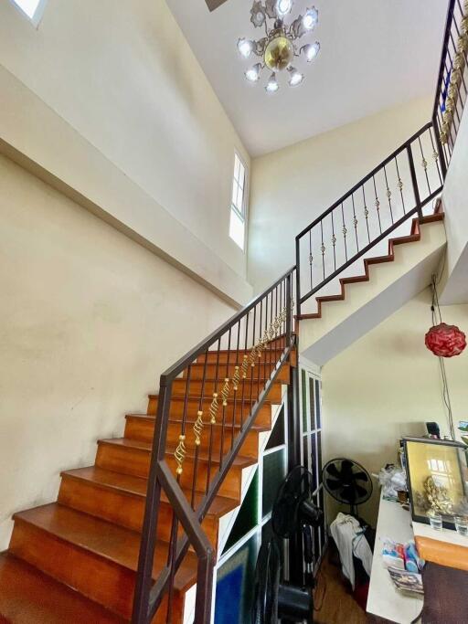 An indoor staircase with wooden steps and decorative railing