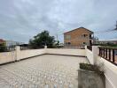 Spacious outdoor patio with tiled flooring and railing