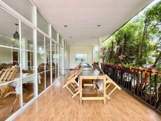 Spacious patio with wooden furniture and large glass windows