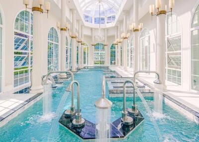 Luxurious indoor pool with high ceiling and large windows