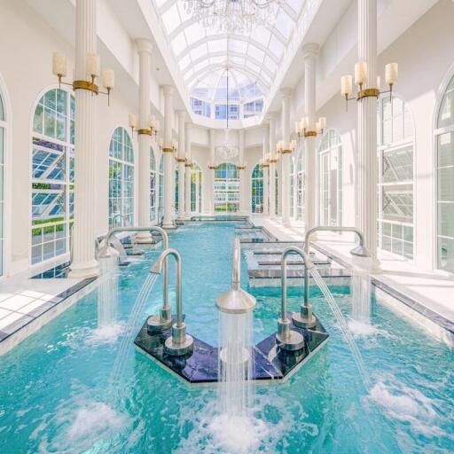 Luxurious indoor pool with high ceiling and large windows