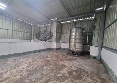 Large empty storage shed with water tank and satellite dish