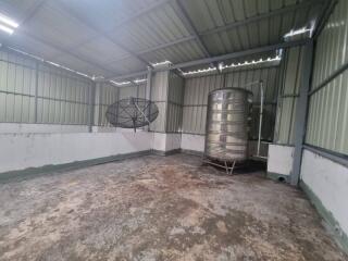 Large empty storage shed with water tank and satellite dish