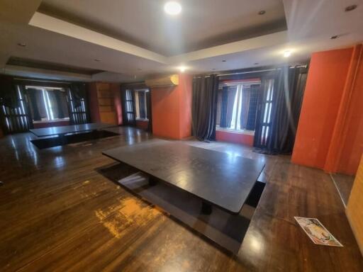 Spacious living room with dark wood flooring and recessed lighting