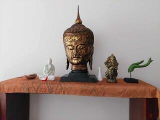 Decorative table with Buddha head and other ornaments