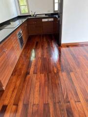 Modern kitchen with wooden flooring and dark countertops