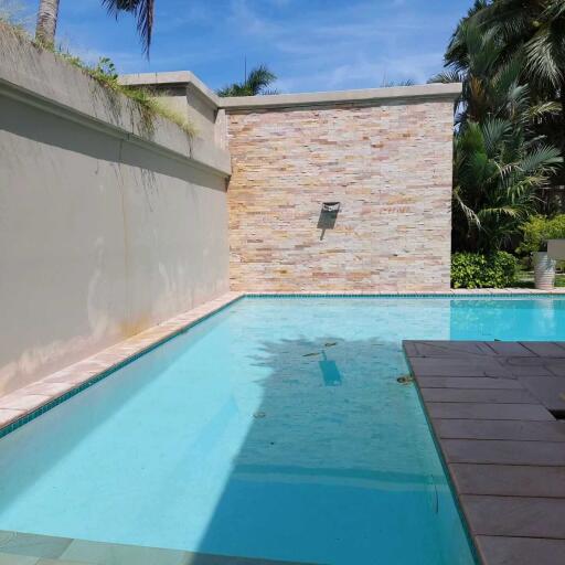 Private pool with surrounding deck and wall