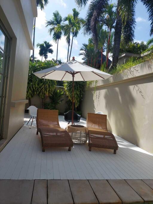 Outdoor patio with lounge chairs and umbrella