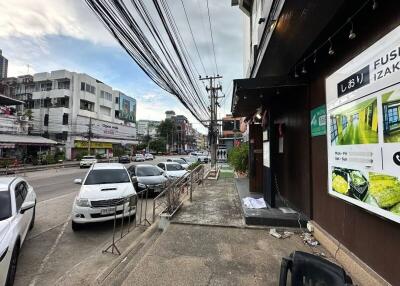 Street view with buildings, cars, and sidewalk