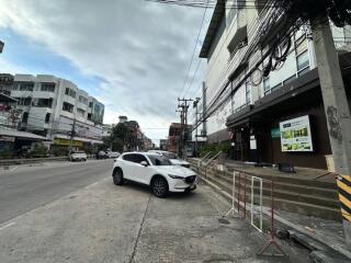 Street view in front of a building with cars parked