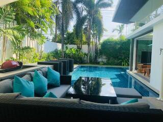 Outdoor living area with pool and greenery