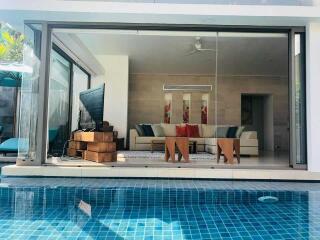 Modern living room view from the pool with glass sliding doors
