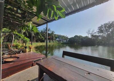 Outdoor seating area by a lake with foliage