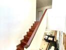 Interior staircase with wooden steps and white walls