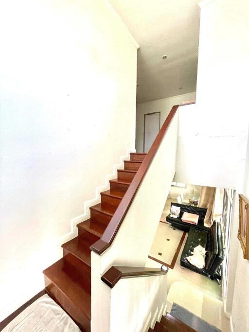 Interior staircase with wooden steps and white walls