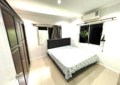 Bright bedroom with large windows, wardrobe, and air conditioning unit