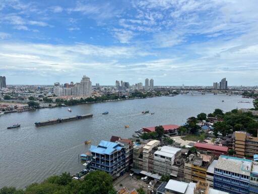 Cityscape view of riverside buildings and boats with a clear blue sky