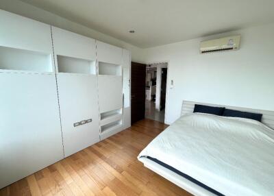 Modern bedroom with hardwood floor and built-in storage