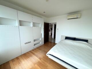 Modern bedroom with hardwood floor and built-in storage