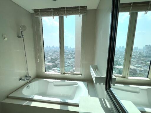 Bathroom with a large window and city view