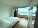 Spacious bedroom with large window and waterfront view