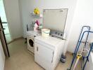 Laundry room with washing machine, dryer, and cleaning supplies