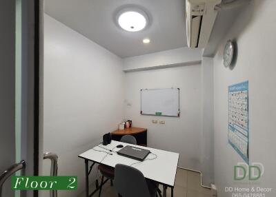 Photo of a small office or study room on the second floor, featuring a desk, chairs, whiteboard, and air conditioning.