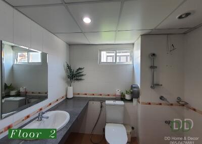 Modern bathroom on second floor with large mirror, sink, toilet, and shower.