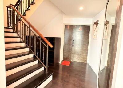 Wide hallway with stairway and entrance door