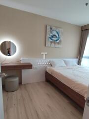 Modern bedroom with a wooden bed, wall art, and a vanity desk with a mirror