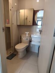 Modern bathroom with a sink, toilet, and storage cabinets