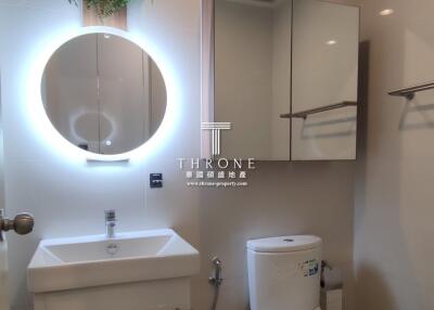 Modern bathroom with illuminated mirror and hanging plant