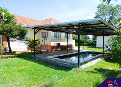 Covered backyard with swimming pool and seating