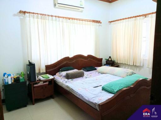 Bedroom with a large bed, air conditioning, and neatly arranged furniture