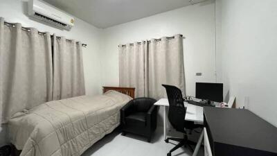 Modern bedroom with bed, desk, and computer